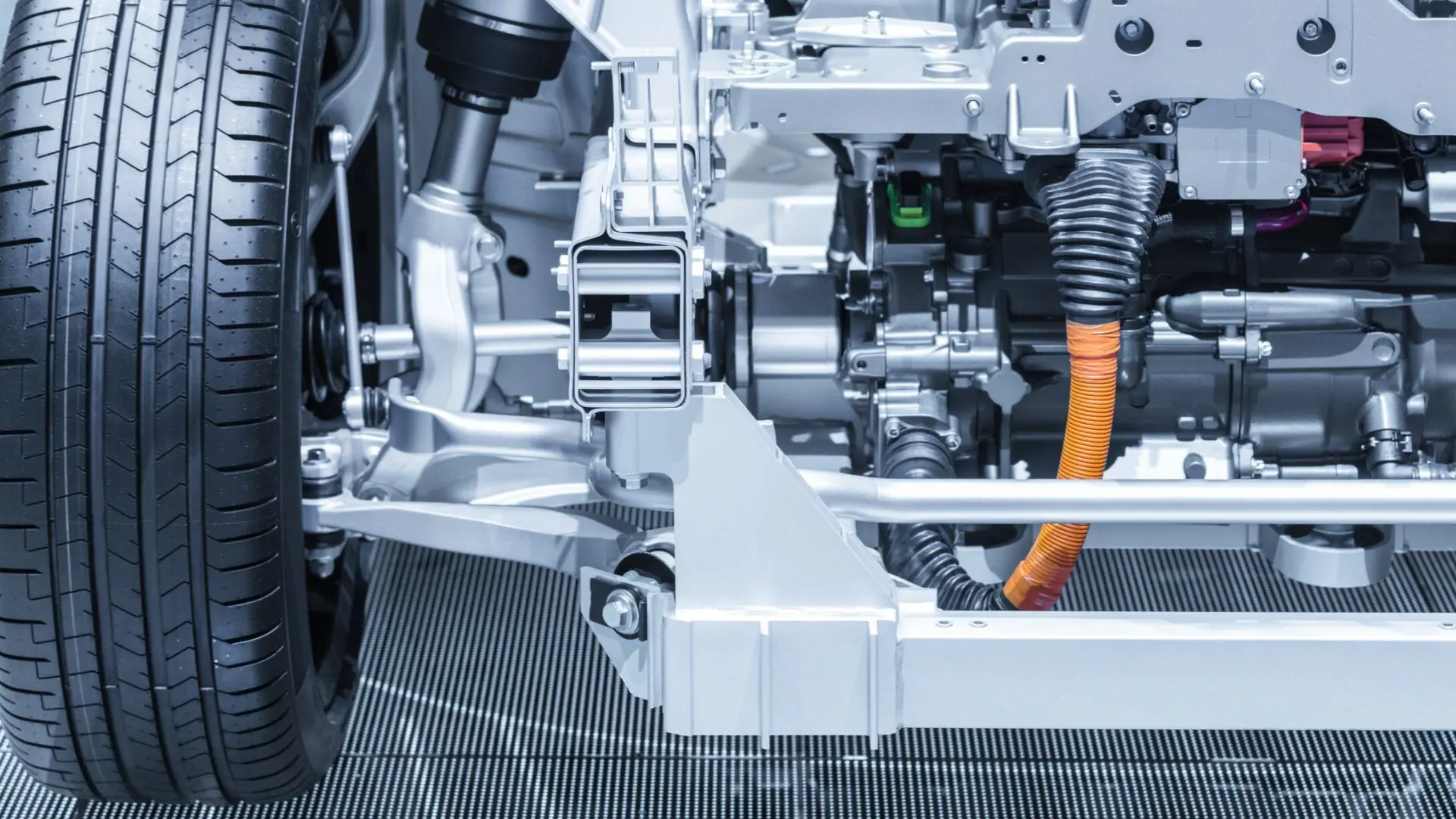 close-up of a hybrid vehicle undercarriage showing orange high-voltage cables and drivetrain components