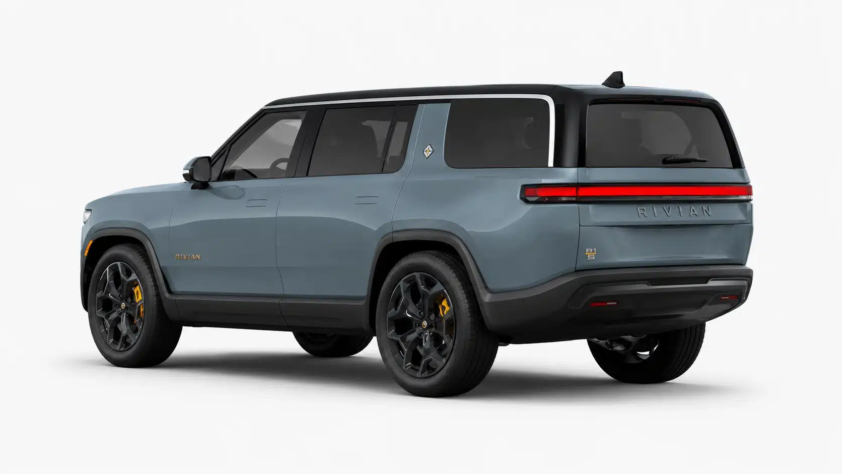 Gray Rivian R1S electric SUV shown from the rear side on a plain white studio background.