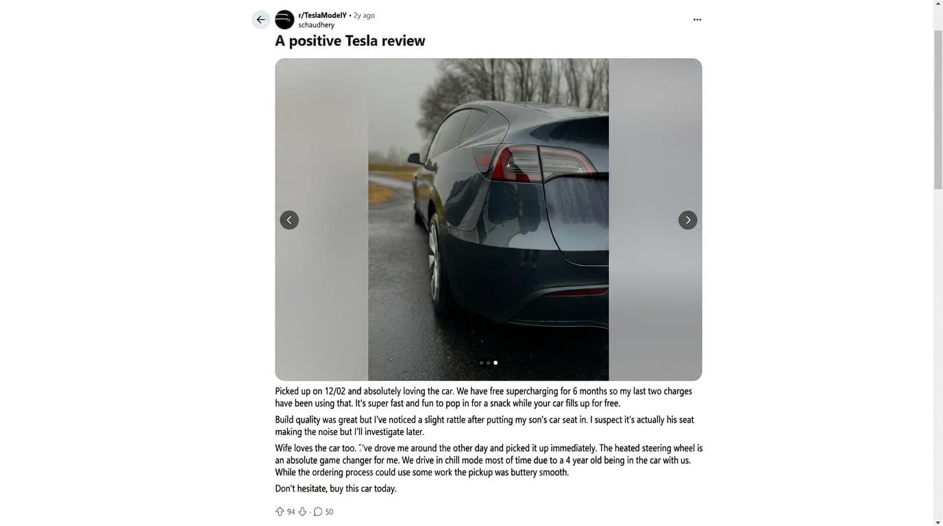reddit post showing a dark tesla model y rear view parked on a wet road with a positive ownership review