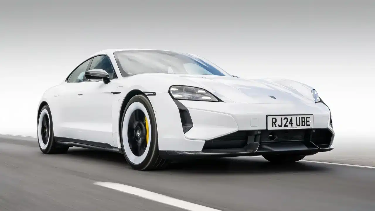 White Porsche Taycan Turbo S electric car on an open road.